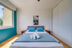 una camera da letto con un letto grande con asciugamani sopra di La Villa 4 You - Maison avec piscine à Bordeaux a Bordeaux