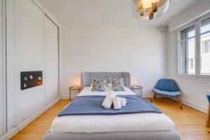 una camera da letto con un letto con due asciugamani sopra di La Villa 4 You - Maison avec piscine à Bordeaux a Bordeaux