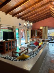 a living room with a large couch and a tv at Casa de campo El Valle Inn in Lima