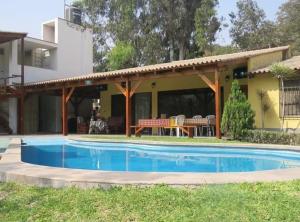 a swimming pool in front of a house at Casa de campo El Valle Inn in Lima