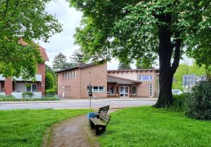 a park bench sitting in the grass next to a tree at Ferienwohnung am Rathenauplatz in Oberhausen