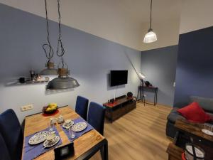 a living room with a table and a couch and a television at Ferienwohnung am Rathenauplatz in Oberhausen