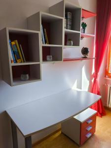 - un bureau blanc dans une chambre avec des étagères dans l'établissement Casa vacanze Ovidio, à Sulmona