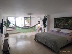 a bedroom with a bed and a hammock in it at Habitación de lujo en hermosa casa frente al mar in Cartagena de Indias