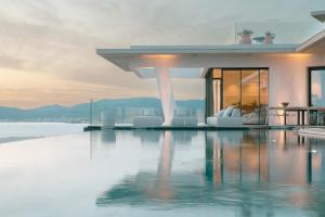a house with a swimming pool with a view of the water at Villa Urbana in Porticcio