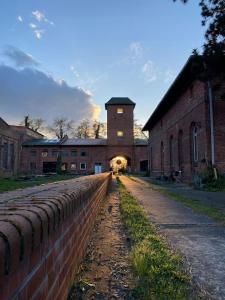 an old brick building with a clock tower in the distance at Modernes Tiny House in historischem Ambiente in Neu Kaliß