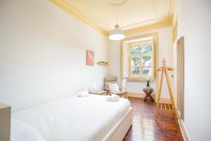 a bedroom with a white bed and a window at GuestReady - Classical Portuguese Style Family Apt in Bohomeain Alfama in Lisbon