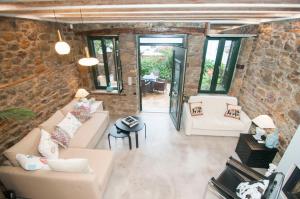 an open living room with a stone wall at Nephelis Heritage House in Moúdhros