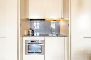 a kitchen with white cabinets and a sink at GuestReady - Time Out 105 in Lisbon