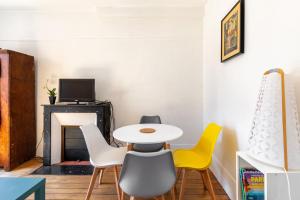stół i krzesła w pokoju z kominkiem w obiekcie GuestReady - Apt Chaleureux dans le 5e arrondissement w Paryżu