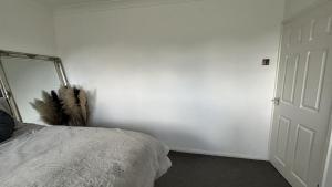 a bedroom with a bed and a mirror on the wall at Romford Cozy Retreat in Romford +2 photos