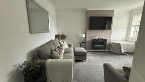 a living room with a couch and a tv at Romford Cozy Retreat in Romford