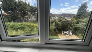 an open window with a view of a dog in a yard at Romford Cozy Retreat in Romford