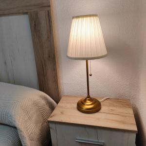 a lamp on a table next to a bed at Apartamento Playa Tanguillos del Mar in Cádiz