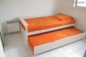 two beds in a small room with orange sheets at Maisonnette 37 m2 Wi-Fi, PKG, Clim in Lattes