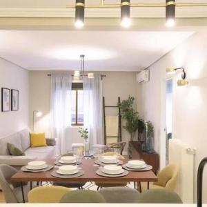 een woonkamer met een tafel en een bank bij GuestReady - Un Moderno Apartamento a un Paso de la Plaza Mayor in Madrid