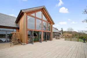 a house being constructed with glass windows and a wooden deck at Enterkine Country House Resort in Annbank