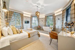 a bedroom with a bed and a tub and a bathroom at Enterkine Country House Resort in Annbank