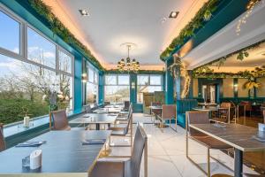 a restaurant with tables and chairs and windows at Enterkine Country House Resort in Annbank