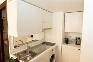 une cuisine blanche avec un évier et un lave-vaisselle dans l'établissement Antuela Pantheon, à Rome