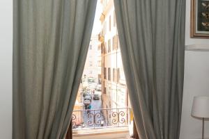 - un balcon avec des rideaux offrant une vue sur la ville dans l'établissement Antuela Pantheon, à Rome 16 autres photos