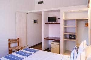 a bedroom with a bed and a desk and a tv at Hotel Blaumar Cadaqués by Fimedhotels in Cadaqués