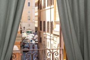 une vue d'une rue de la ville depuis un balcon avec des rideaux dans l'établissement Antuela Pantheon, à Rome