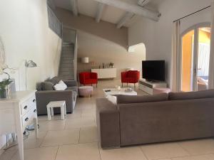a living room with a couch and a tv at Villa spacieuse proche de Marseille avec jardin et piscine privée in La Tour-dʼAigues