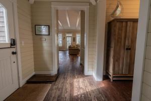 a hallway of a home with wooden floors and a door at Nantucket House by Seabrook Hospitality in Pacific Beach