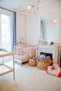 una cameretta per bambini con una culla, uno specchio e una culla di Luxury Apt Paris 7 Invalides Tour Eiffel a Parigi
