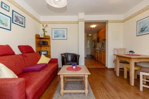 ein Wohnzimmer mit einem roten Sofa und einem Tisch in der Unterkunft Meeresblick Meeresblick 206 in Kühlungsborn