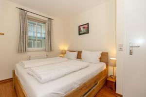 ein Schlafzimmer mit einem weißen Bett mit einem Fenster in der Unterkunft Meeresblick Meeresblick 206 in Kühlungsborn