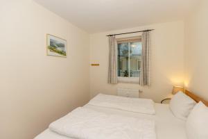 ein Schlafzimmer mit einem weißen Bett und einem Fenster in der Unterkunft Meeresblick Meeresblick 206 in Kühlungsborn