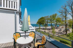 ein Balkon mit Tisch und Stühlen und dem Meer in der Unterkunft Meeresblick Meeresblick 206 in Kühlungsborn