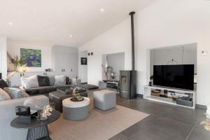 a living room with a couch and a flat screen tv at Panorama Beach Villa 4p - Premium Comfort & Uitzicht - Villa 25 in Ouddorp
