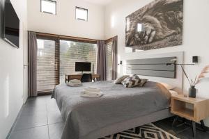 a bedroom with a bed and a desk with a computer at Panorama Beach Villa 4p - Premium Comfort & Uitzicht - Villa 25 in Ouddorp