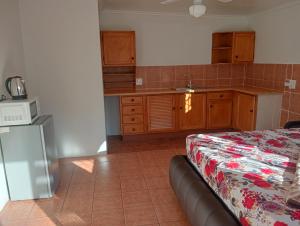 a room with a kitchen with a bed and a microwave at Moonlight Guest House in Johannesburg