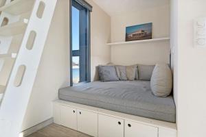 a bed in a room with a window at Luxury Beachfront Villa 4p - Uitzicht op de Baai & Duinen - Villa 19 in Ouddorp