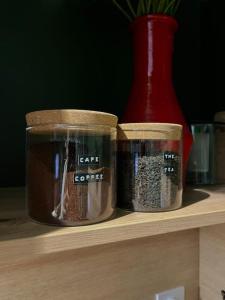 two containers of spices sitting on a shelf with a vase at La cabane tropicale in Pontorson +18 photos