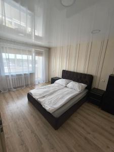 a bedroom with a bed and a large window at Sky View in Marijampolė