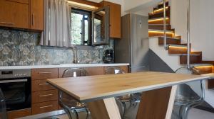 a kitchen with a wooden table and chairs at ApoLoveSea in Megali Ammos