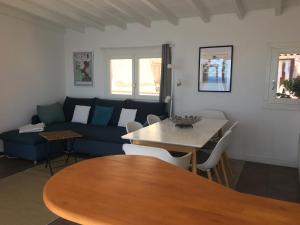 a living room with a blue couch and a table at Triplex entre ciel et mer in Roquebrune-Cap-Martin
