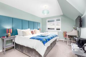 a bedroom with a large bed with a blue wall at Heartseed House Bed & Breakfast in Dornoch