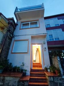 una casa blanca con una puerta y escaleras en Casa do Campo e Mar, en Finisterre