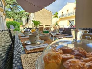 a table with a plate of food and wine glasses at Les Gîtes de Monte Blanco - Chambres d'hôtes et gîtes in Montblanc