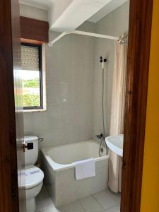 a bathroom with a white tub and a toilet at El Castañu de Cué in Cue +8 photos