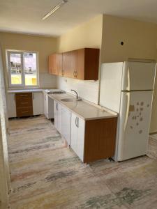 an empty kitchen with white appliances and a refrigerator at Ümit 2 Termal Apart Pansiyon in Pamukkale