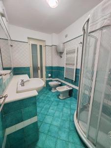 a bathroom with two toilets and a tub and a sink at gardeniapartment in Minori