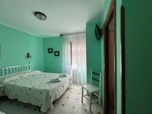 a green bedroom with a bed and a chair at El Castañu de Cué in Cue