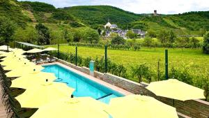 eine Reihe gelber Sonnenschirme neben einem Swimmingpool in der Unterkunft Mosel Village Resort in Ellenz-Poltersdorf + 171 Fotos